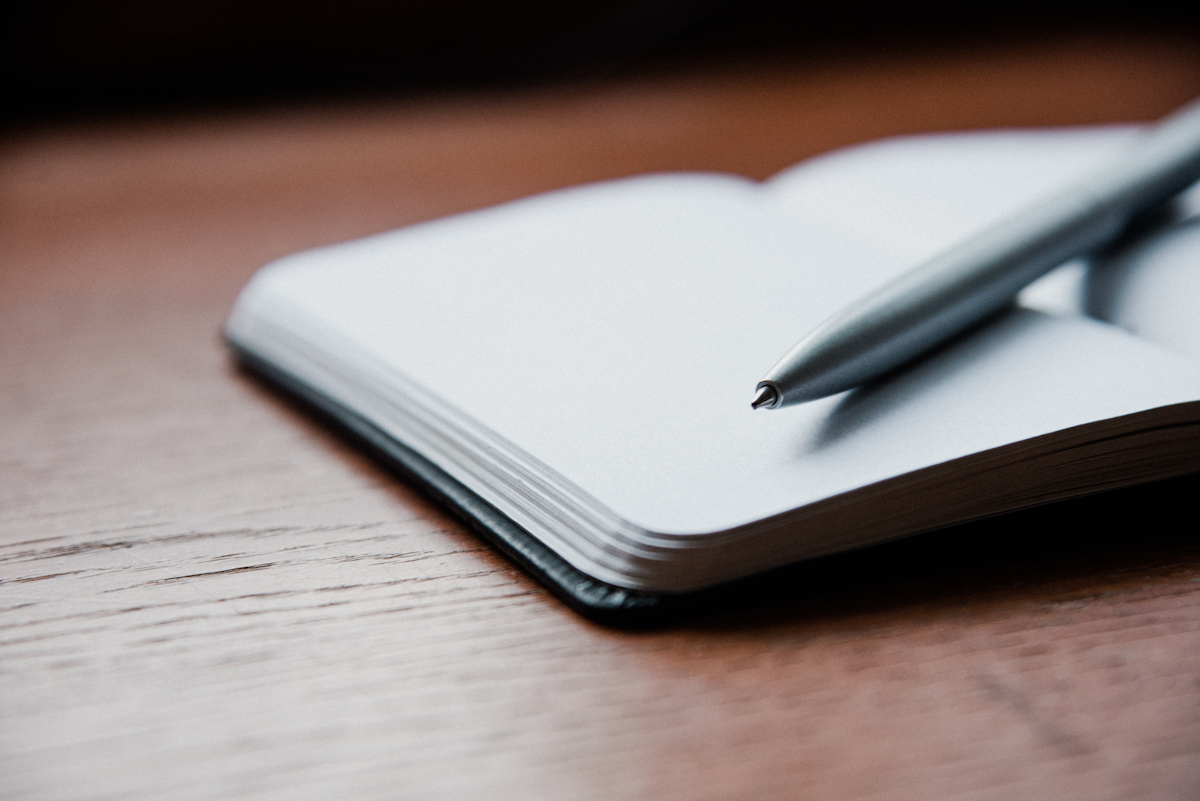 Caderno com anotações e caneta em mesa de trabalho